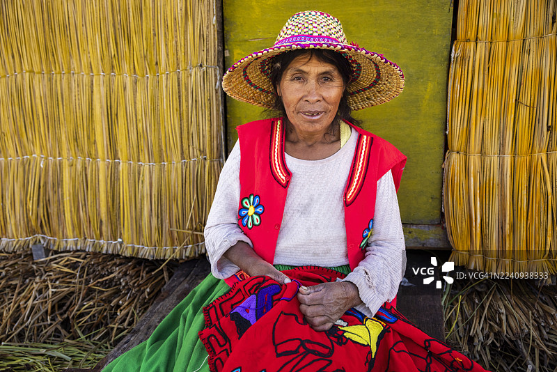 秘鲁乌鲁斯浮岛上的秘鲁年轻女子售卖纪念品，的的喀喀湖，秘鲁图片素材