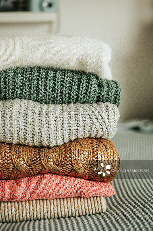 堆叠的舒适毛衣，采用温暖的秋冬色调，图片素材