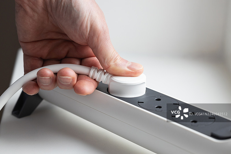 男人的手将电源插头插入插座图片素材