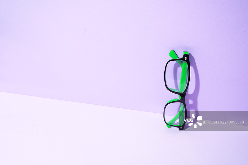 紫色背景下带有阴影的眼镜图片素材