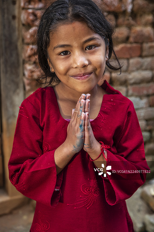 尼泊尔巴克塔普尔，一位年轻尼泊尔女孩的合十礼肖像图片素材