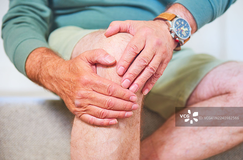 男人按摩疼痛的膝盖图片素材