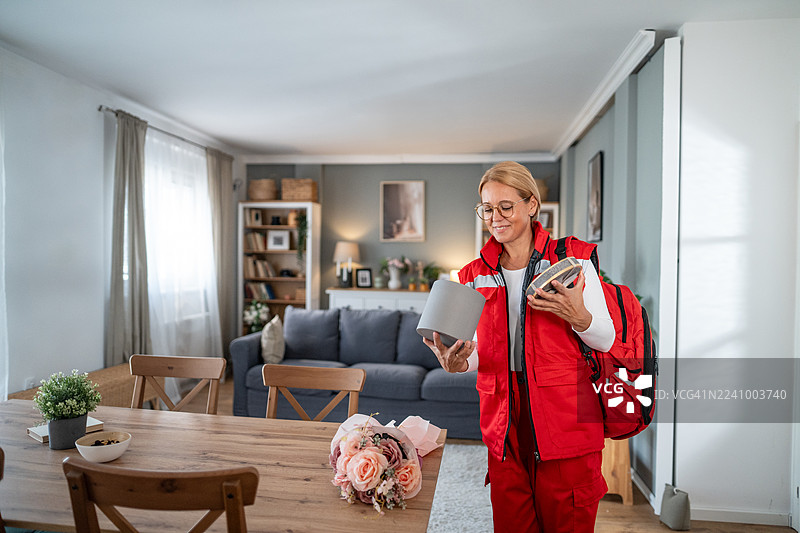 微笑的医护人员在家访时收到鲜花和礼物图片素材