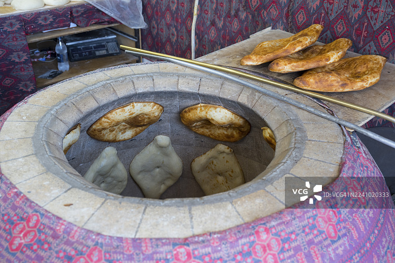 传统粘土烤炉，炉壁上烤着馕饼，烤炉，坦杜里，坦杜尔，托尼尔，马尔图尼，亚美尼亚盖加尔库尼克省图片素材