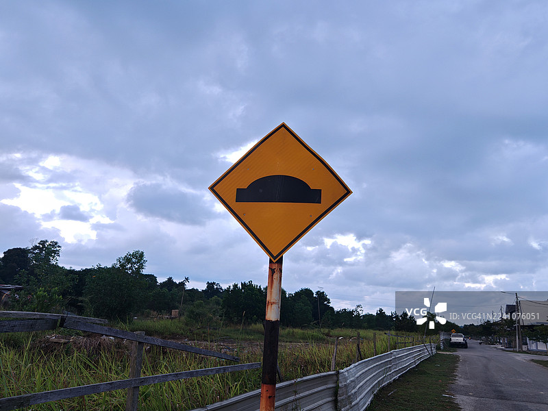 马来西亚，路标指示前方有减速带，背景是多云的天空图片素材