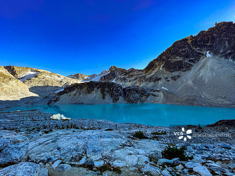 加拿大布拉克戴尔，湛蓝冰川湖泊坐落于白雪皑皑的山峦之间，在晴朗的蓝天下展现出大自然的原始之美。图片素材