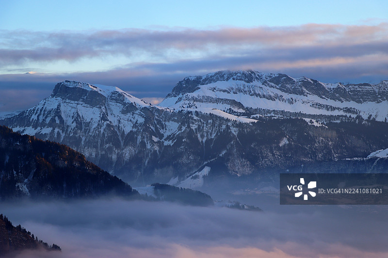 日落时分，雄伟的雪山笼罩在薄雾中，营造出宁静空灵的风景，瑞士韦吉斯，瑞吉卡尔特巴德图片素材