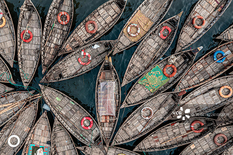 许多色彩鲜艳的木制渔船从空中俯瞰，它们密集地停泊在水面上，形成充满活力的图案，地点为印度萨兰布尔的意大利克赫拉 (Salumber, India, Itali Khera)。图片素材