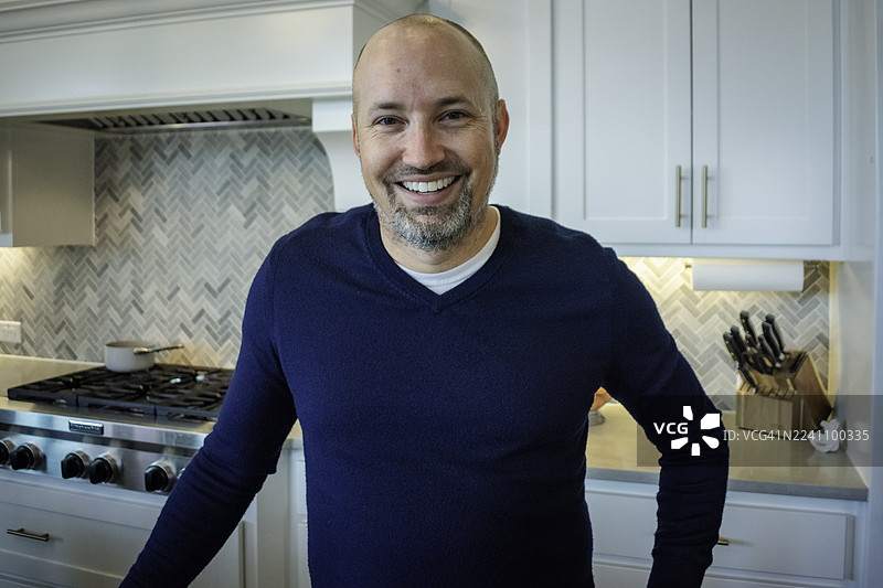 男人站在厨房里对着镜头微笑图片素材