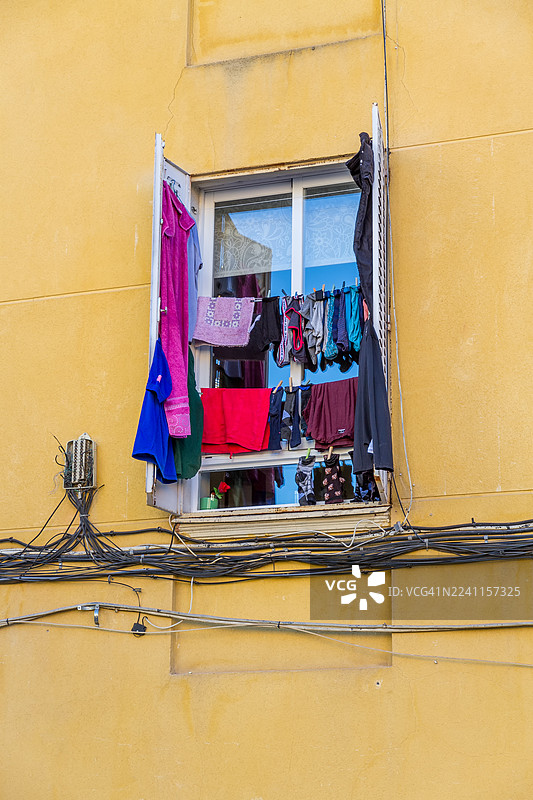百叶窗上晾晒着衣物的一扇窗户图片素材
