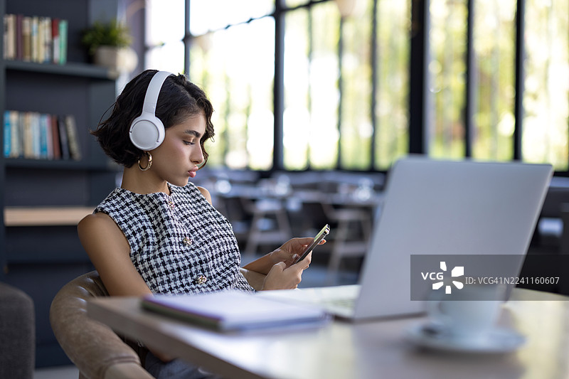 一名女子在咖啡馆里无聊地玩着手机图片素材