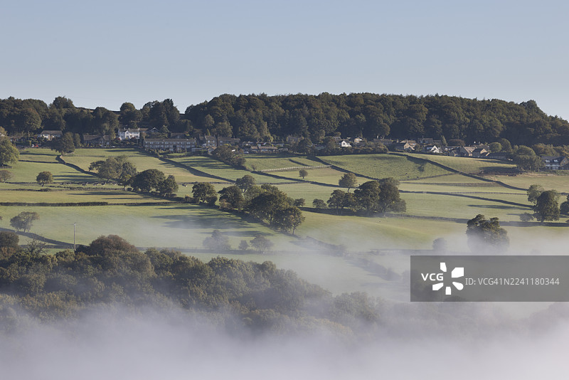 英国西约克郡，迷雾笼罩着贝尔登荒原和霍克斯沃斯村之间的田野。图片素材