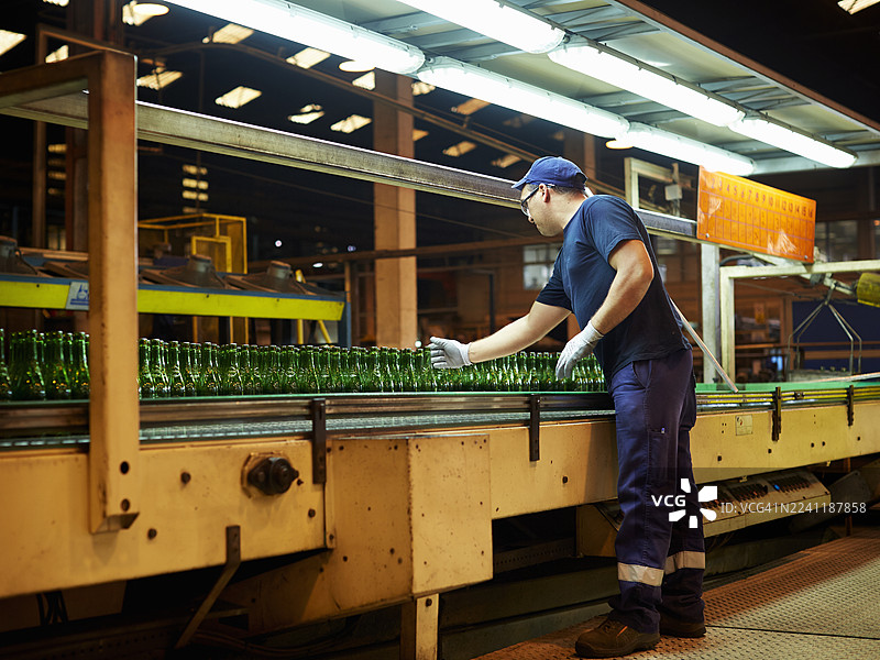 工人检查传送带上的瓶子图片素材