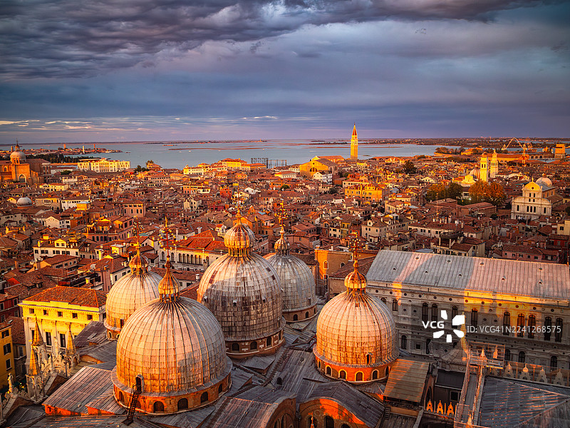 日落时分，威尼斯圣马可大教堂（Basilica di San Marco）及其圆顶呈现出迷人的红色，圣马可区和卡斯泰洛区的屋顶、数座教堂以及威尼斯泻湖构成了一幅绝美景致，这里是意大利威尼托地区的世界文化遗产。图片素材