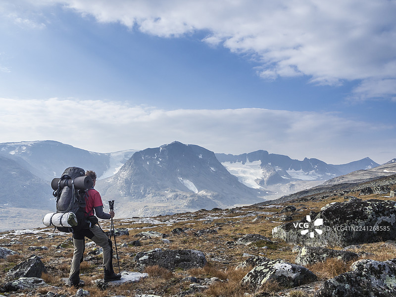 背着背包的徒步旅行者眺望挪威约通黑门山的群山图片素材