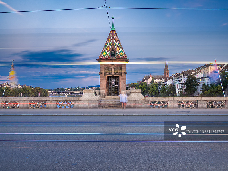 瑞士巴塞尔市，一座横跨莱茵河的古老桥梁米特勒布吕克（Middle Bridge）的夜间长曝光景观，可以看到光轨、小教堂Käppelijoch以及巴塞尔大教堂（或主教座堂）。图片素材