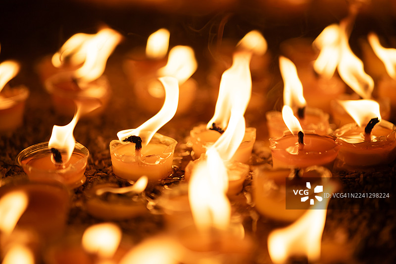 烛光在宗教或精神仪式中于黑暗中闪耀图片素材
