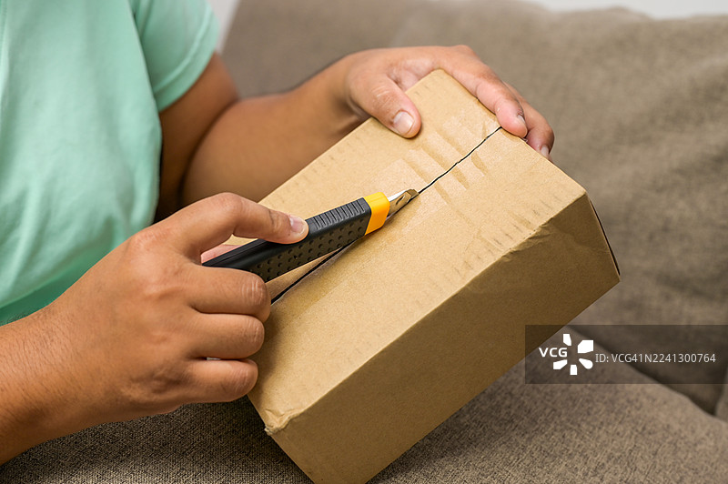 打开纸箱快递盒的手，网购与开箱概念图片素材