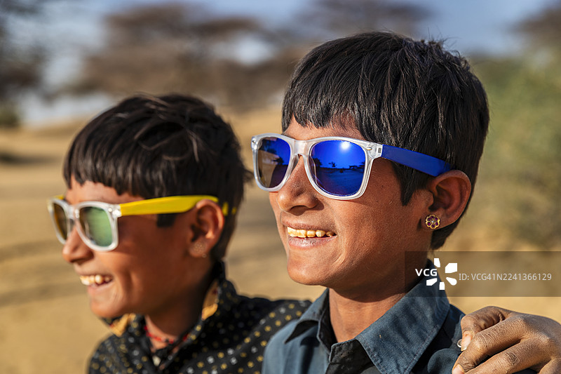 印度年轻男孩戴着太阳镜，沙漠村庄，印度图片素材