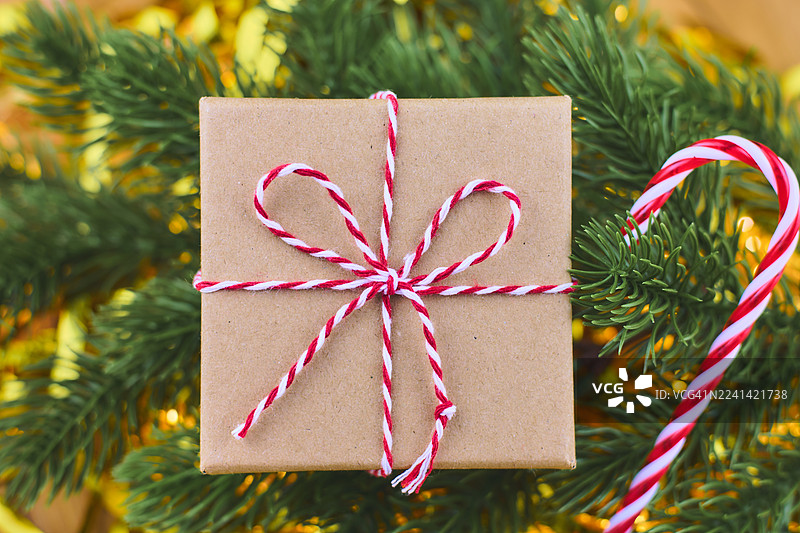 节日礼品盒，旁边有红白丝带、拐杖糖和松枝图片素材