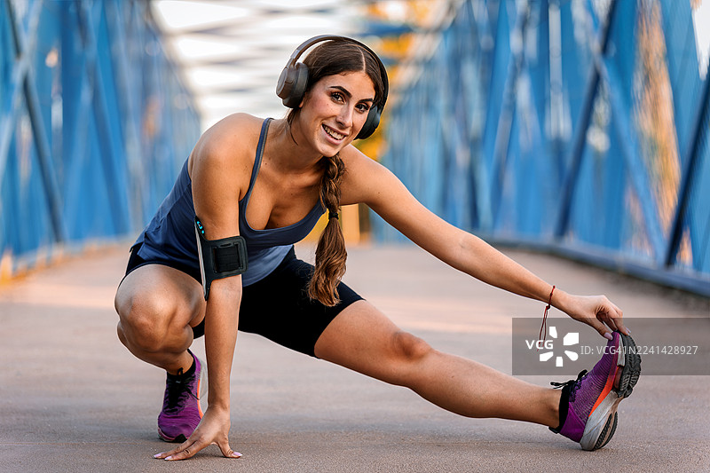 女性在户外锻炼前伸展身体图片素材