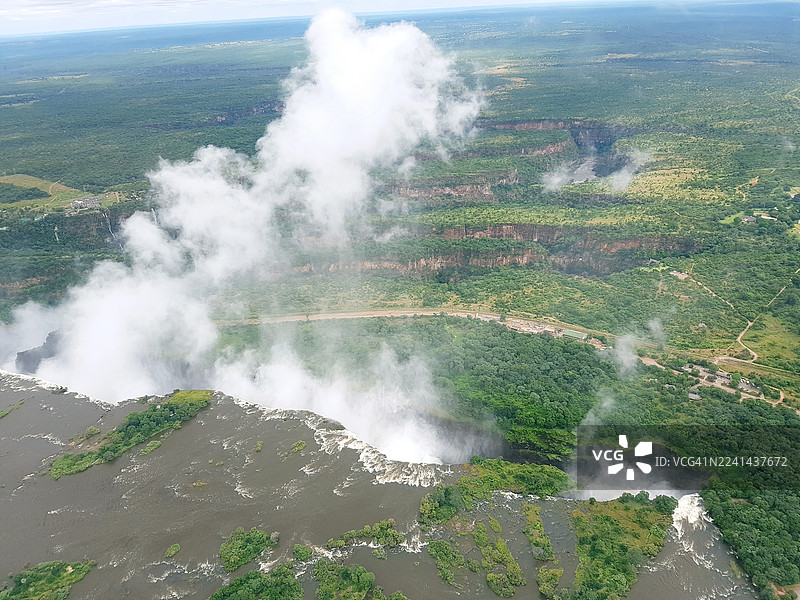 高角度拍摄的维多利亚瀑布，瀑布峡谷升腾起薄雾，周围是郁郁葱葱的绿色景观。图片素材