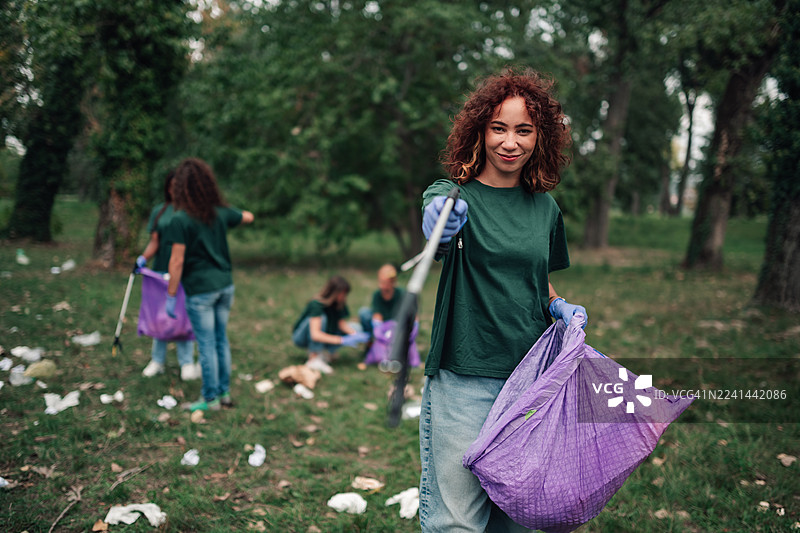 年轻女子在社区志愿清理公园图片素材