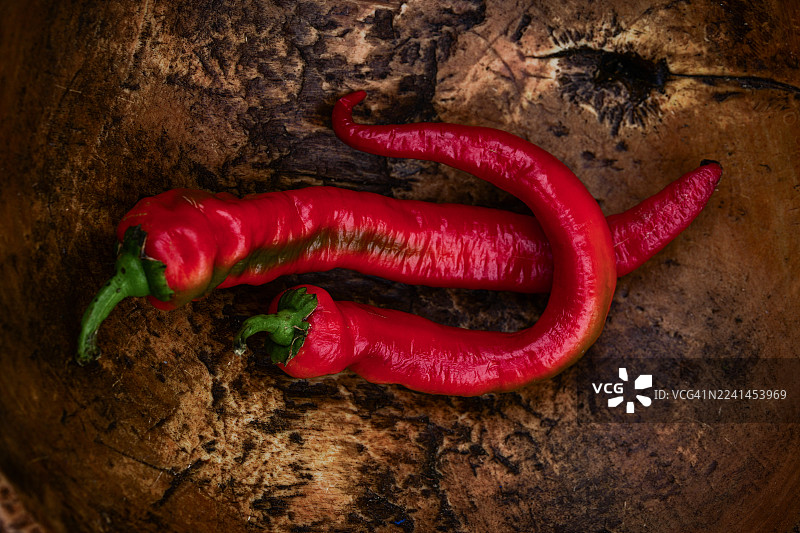 俯视视角下，乡村风格的木质表面上有两个红辣椒图片素材