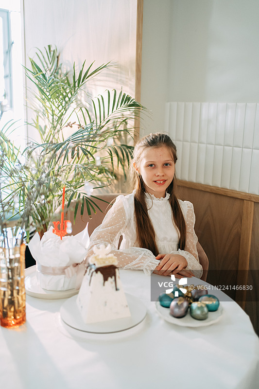 女孩们在庆祝复活节，品尝传统的复活节面包和彩蛋。图片素材