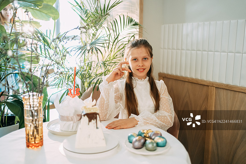 年轻女孩用传统的库里奇和彩蛋庆祝复活节图片素材