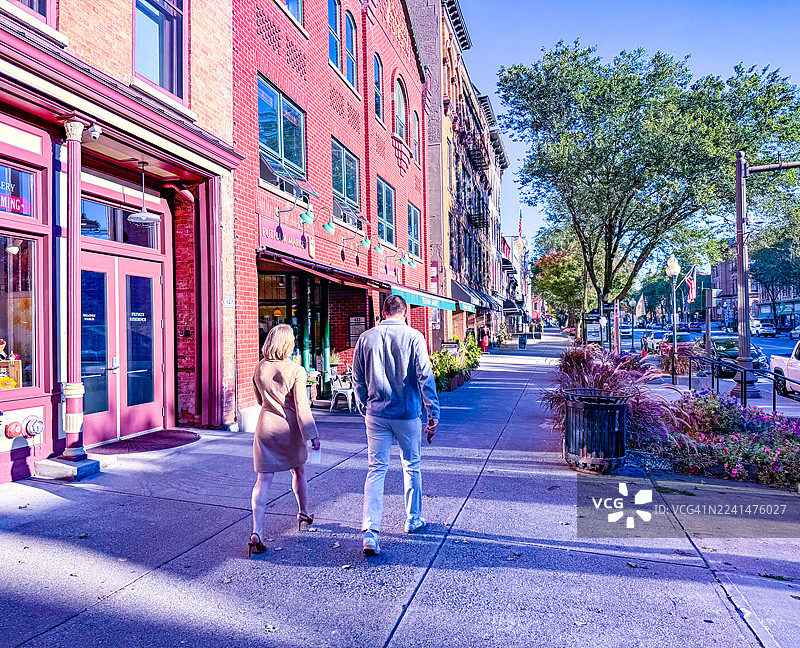 清晨，一对男女走在萨拉托加斯普林斯的百老汇大道上图片素材