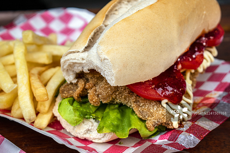炸肉排三明治。炸肉排三明治配生菜和番茄，以及炸薯条。阿根廷传统美食。图片素材