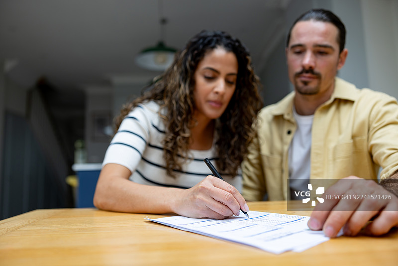 一对夫妇在购买房屋时签署契约的特写图片素材