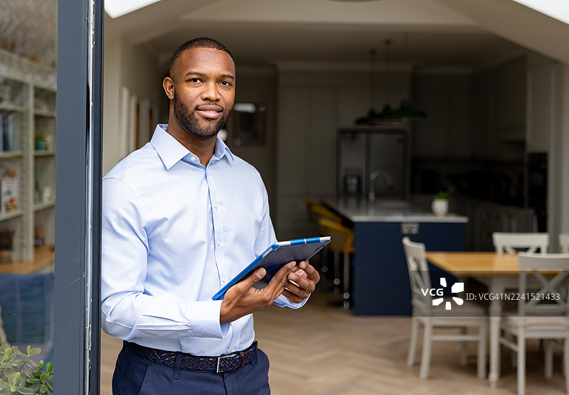 一位房地产经纪人在展示房屋时使用数字平板电脑的肖像图片素材
