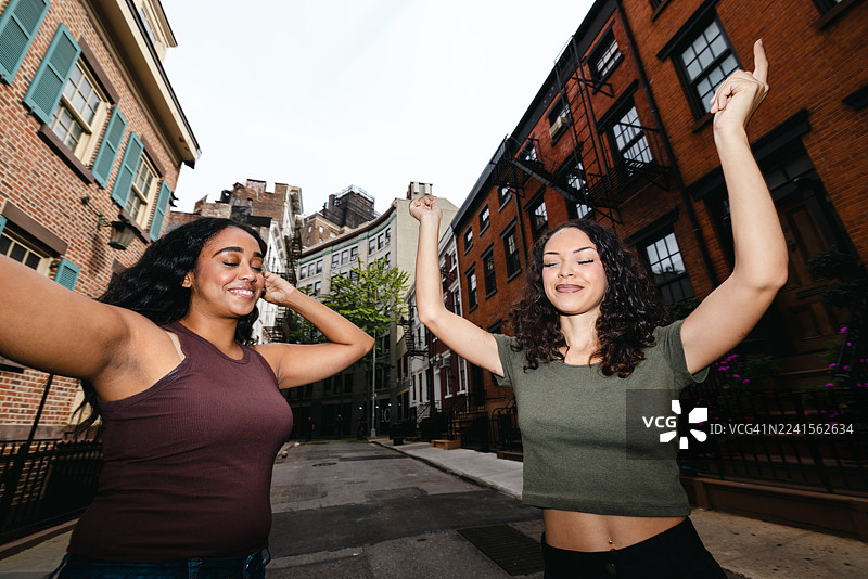 一群朋友在城市街区户外随着音乐一同跳舞，享受欢乐时光图片素材