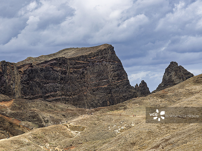 马德拉岛的火山地貌，游客沿着海边山路徒步。图片素材