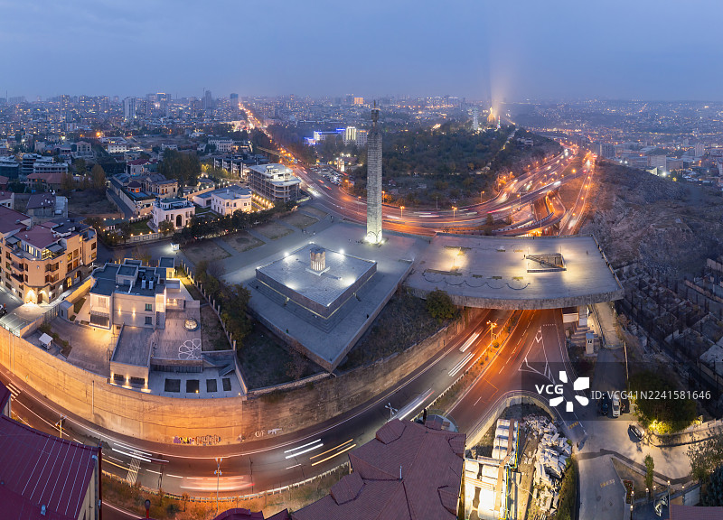 在深邃的蓝色时刻，长曝光的光轨划过亚美尼亚埃里温繁忙的高速公路，照亮了充满活力的首都城市景观。图片素材