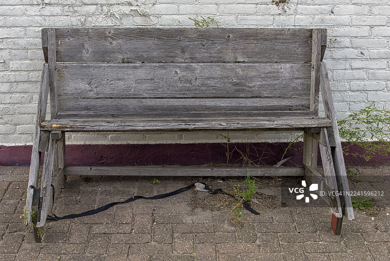 一张饱经风霜的木制长椅摆放在户外图片素材