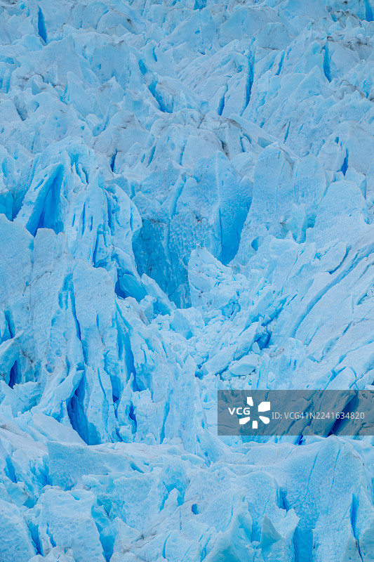 生机勃勃的蓝色冰川全景，展现了寒冷自然环境中的复杂冰层构造和纹理图片素材