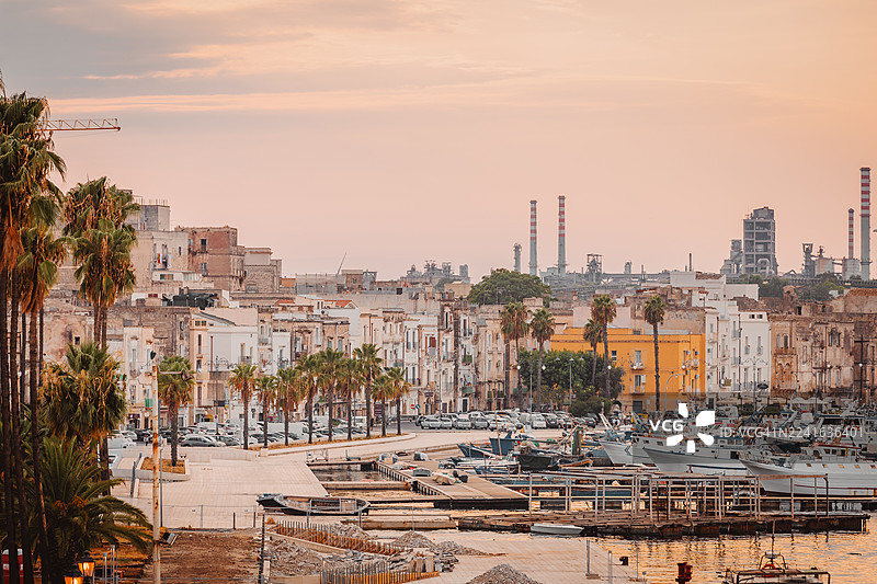 夕阳下的海滨小镇高角度视图，有港口和工业背景，意大利塔兰托图片素材