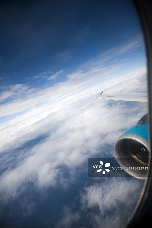 透过机窗看到的飞机机翼和引擎，背景是蓝天白云，摄于飞行途中，地点：西班牙巴塞罗那，加泰罗尼亚图片素材
