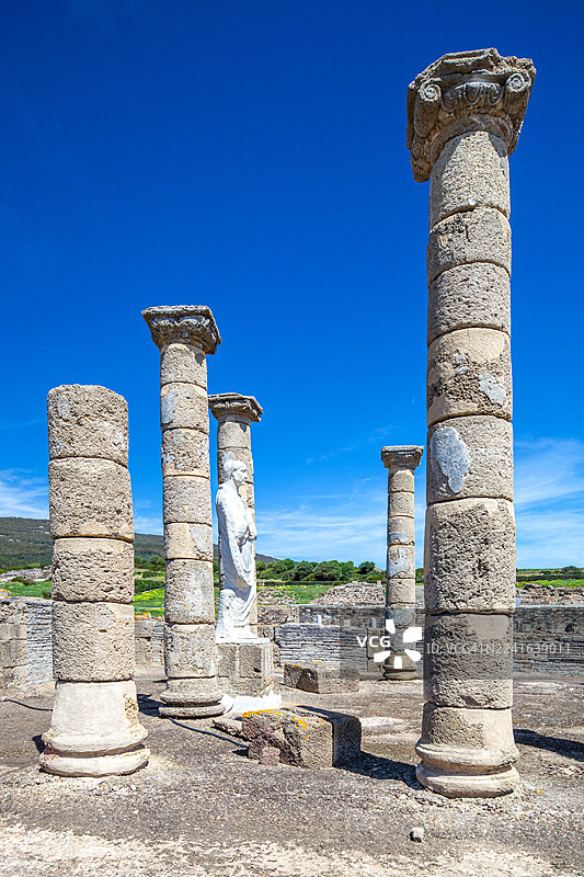 古罗马遗址，高耸的柱子和雕像在晴朗的蓝天下，西班牙博洛尼亚古城，塔里法，西班牙图片素材