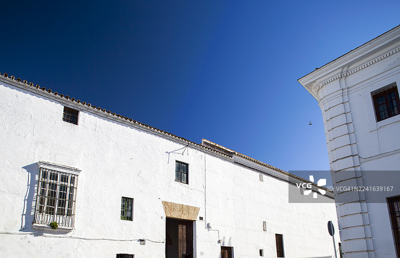 晴朗的阳光下，低角度拍摄的刷白房屋与湛蓝的天空形成鲜明对比，西班牙卡莫纳图片素材