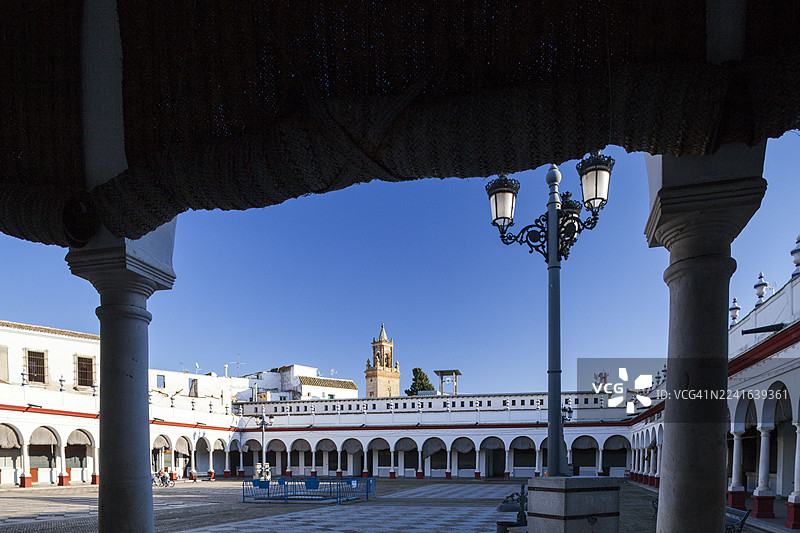 西班牙历史庭院，带有拱门和钟楼，背景为蓝天，地点：卡莫纳，西班牙图片素材