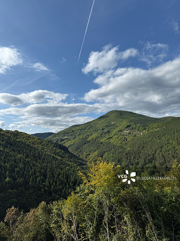 蓝天白云下，碧绿的山峦与山谷，留下一道飞机尾迹，波斯尼亚和黑塞哥维那图片素材