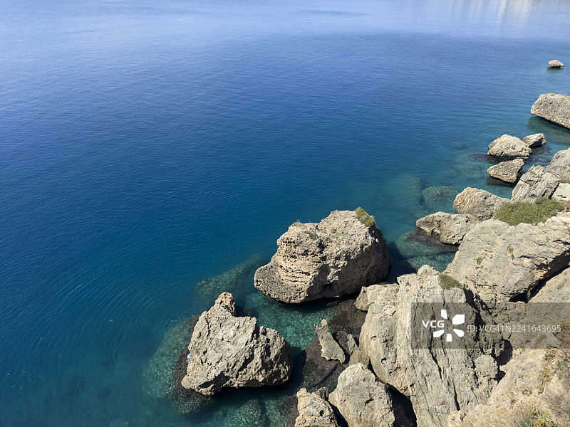 从高处俯瞰土耳其安塔利亚，在明亮的日光下，崎岖的岩石与宁静的蓝色海岸线相映成趣。图片素材