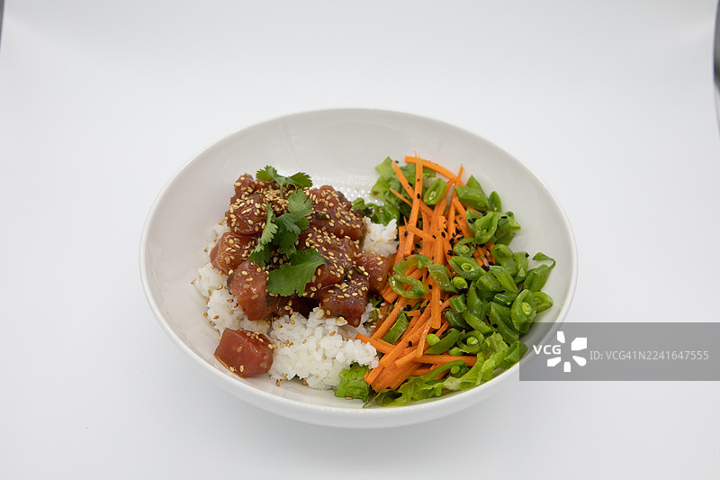 俯视视角拍摄的色彩鲜艳的夏威夷盖饭，包含金枪鱼、米饭和蔬菜，背景为白色。图片素材