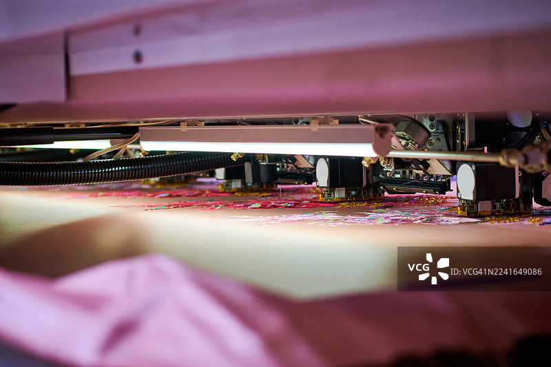 粉色丝绸上自动化刺绣的特写图片素材