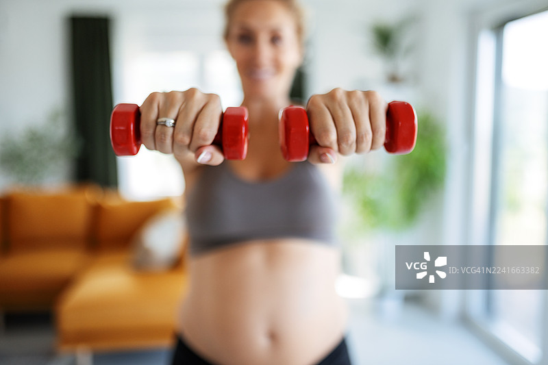 健美的孕妇举小哑铃图片素材