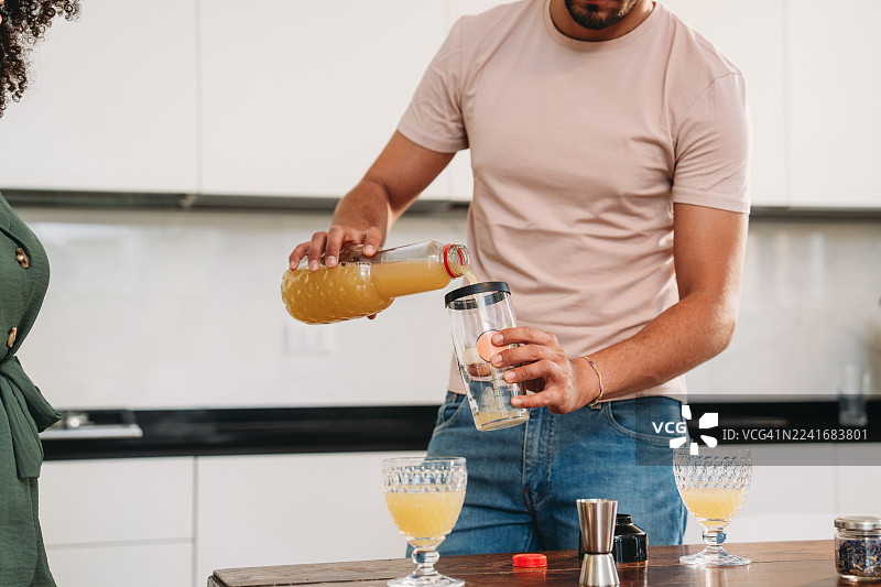 男人将果汁倒入摇酒壶，制作自制鸡尾酒图片素材